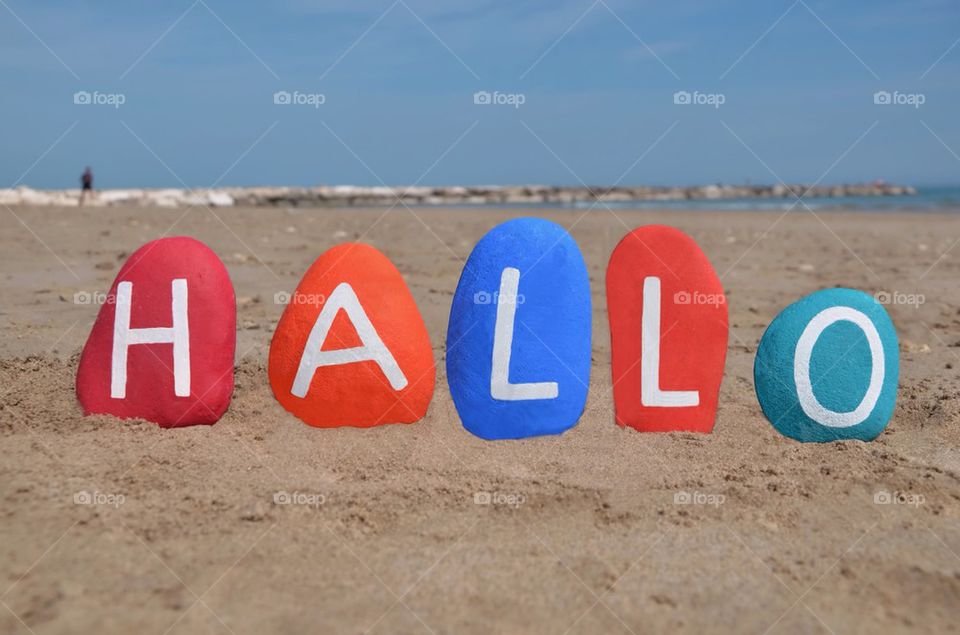 Hallo on colourful stones and beach background