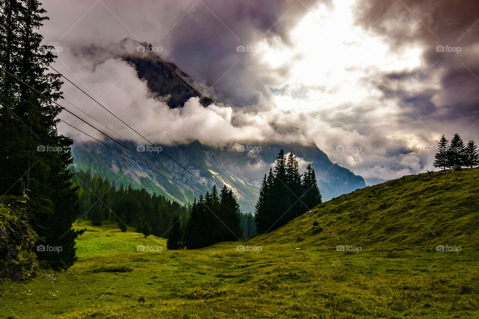Scenic view of clouds over mountains and trees