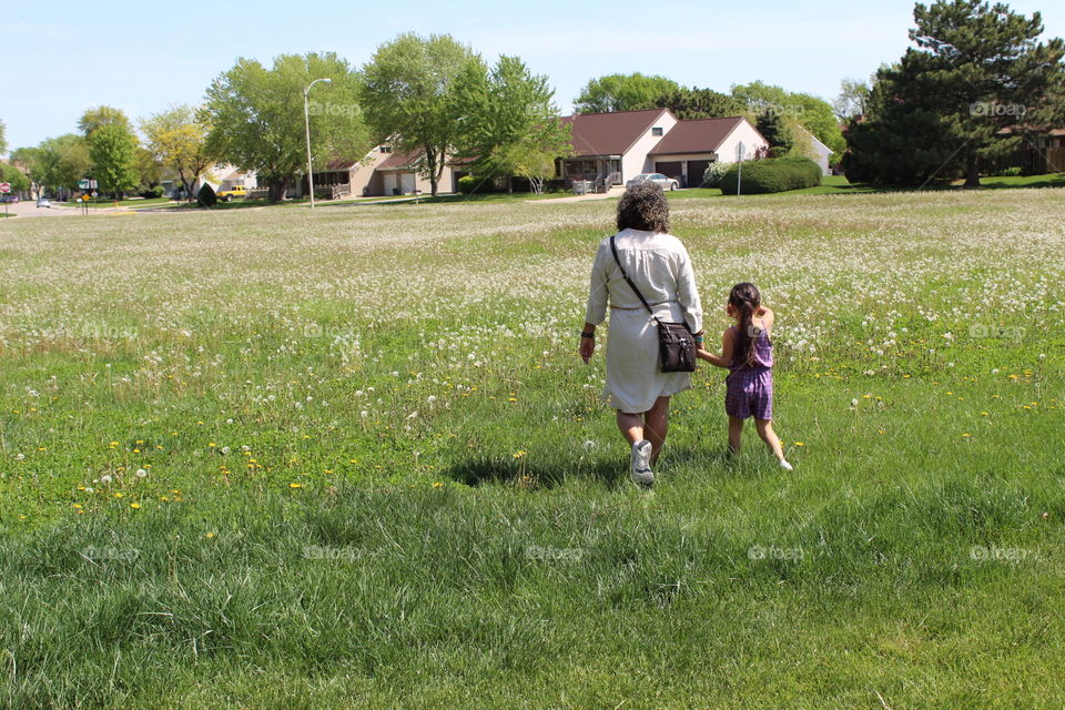 Grandma and her granddaughter walking around the neighborhood in a beautiful day 