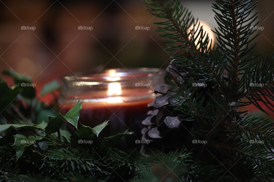 Candle with Holly and Pine Cone.