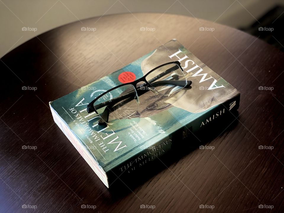 Reading book on the table, photography of reading book and specs on it.