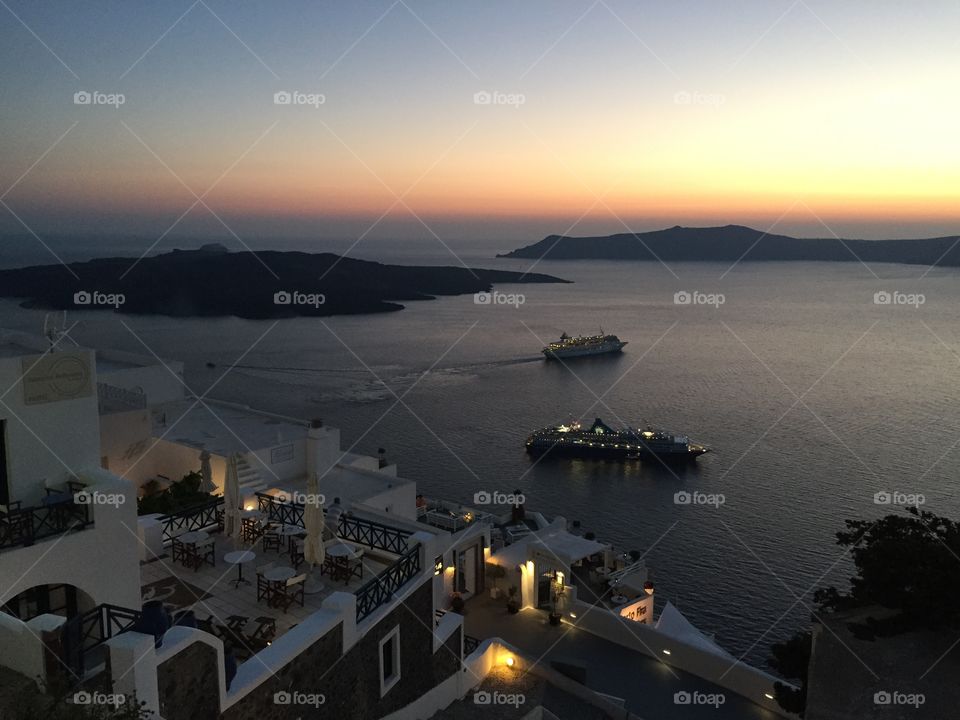 Sunset on Santorini . Cruise ships leaving the Caldera 