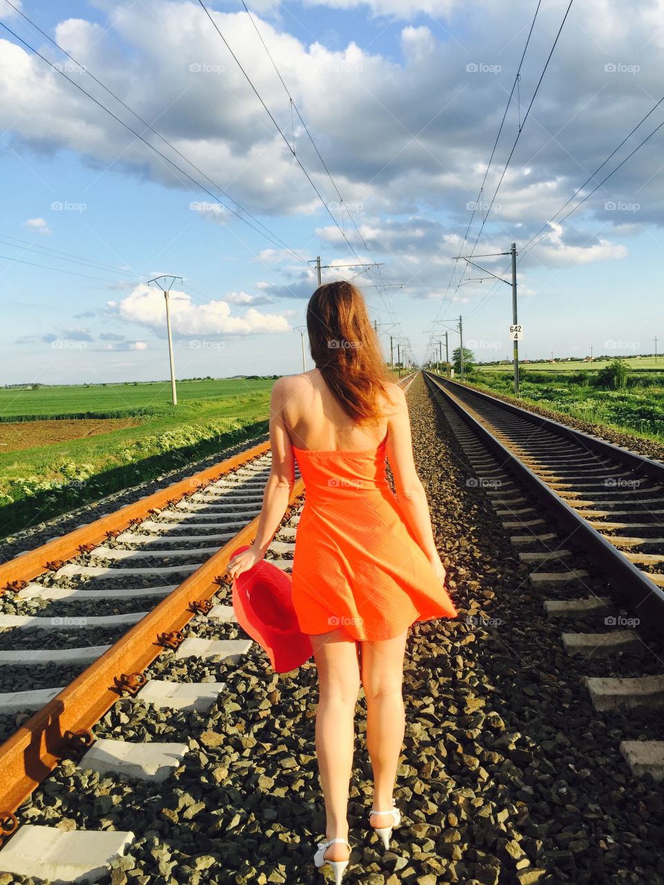 Rear view of girl walking on railroad