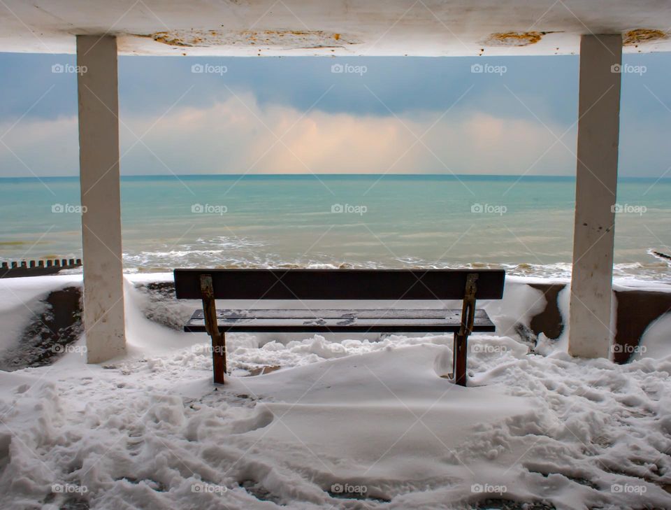 Snow on the promenade looking out at ominous clouds over the English Channel 