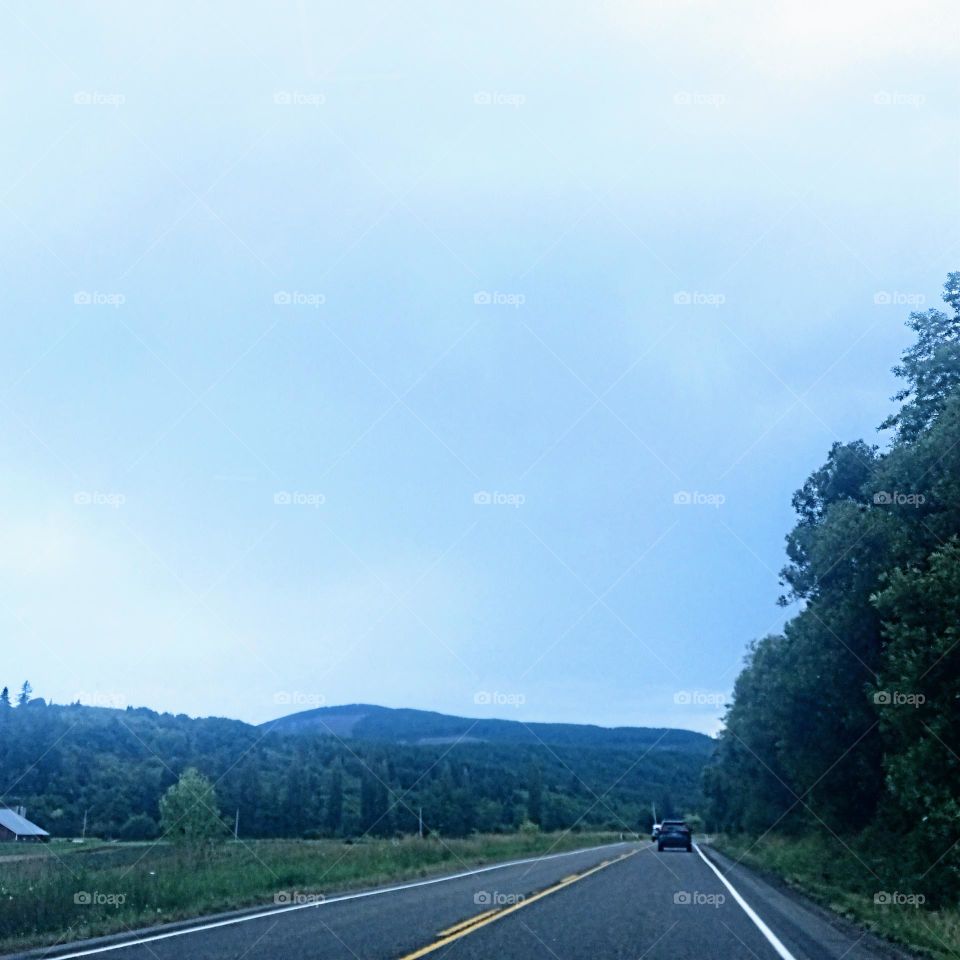 A roadtrip to the canal with a foothill view from the highway  lined with trees on one side and country farmlands on the opposite side