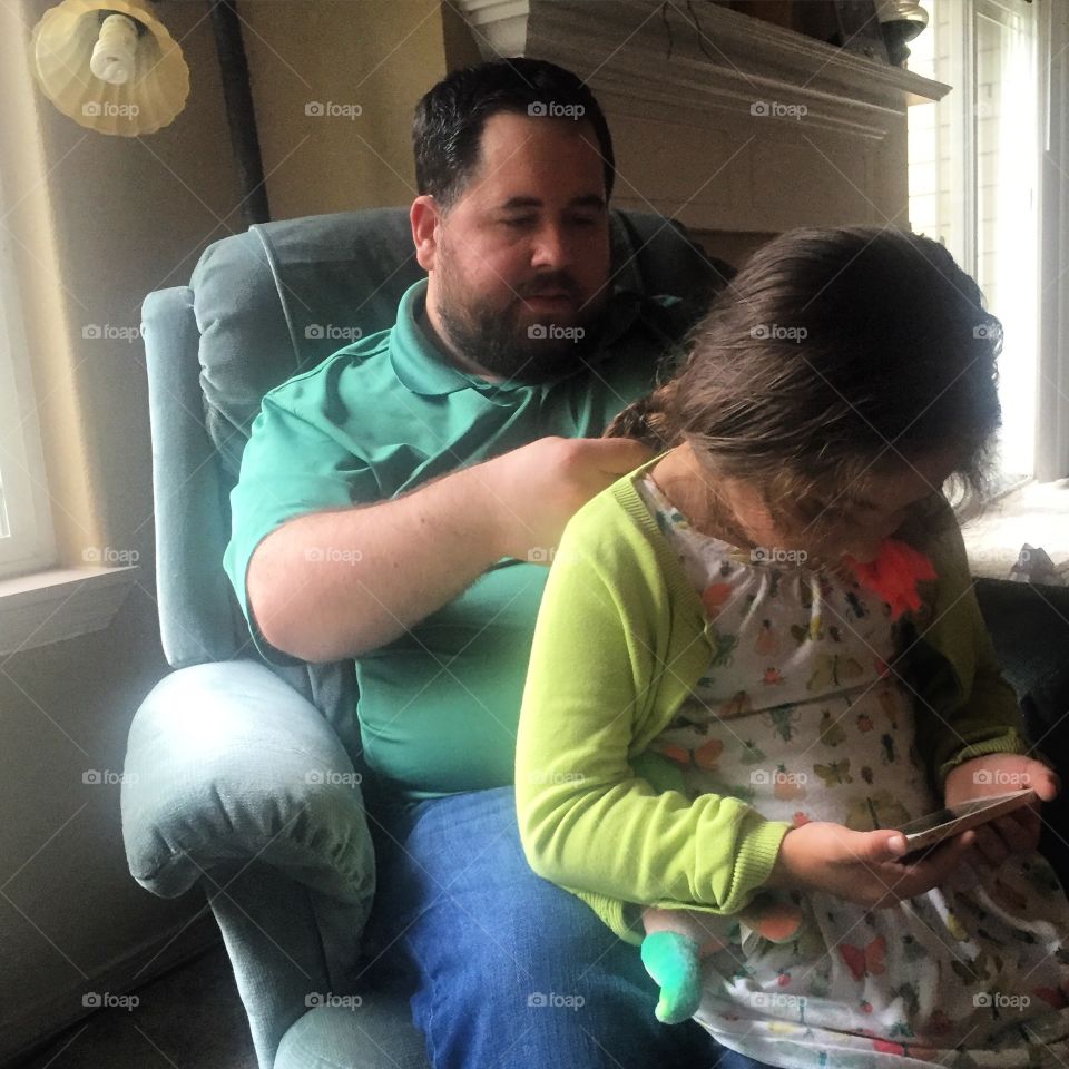 Man braiding a little girls hair