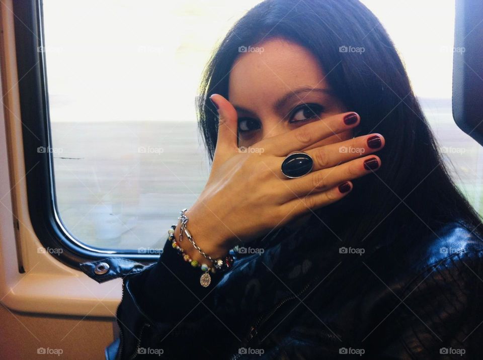 Woman covering her face with hand wearing a black stone ring