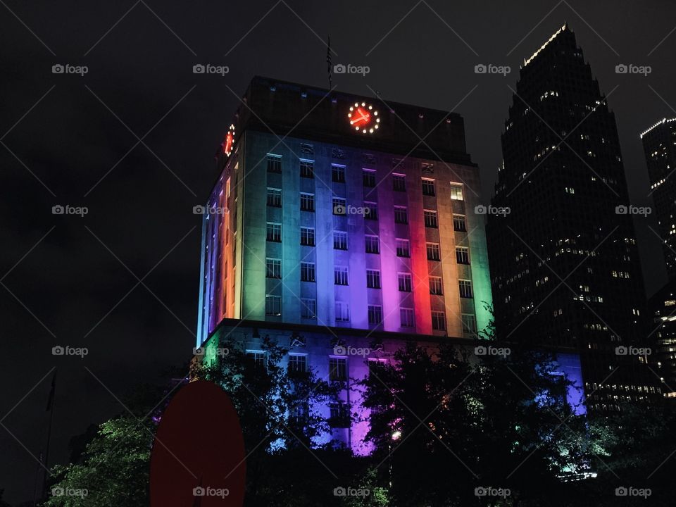 Downtown Houston Texas, during pride month. The rainbow pride illuminated from buildings, shining through the darkest nights.  