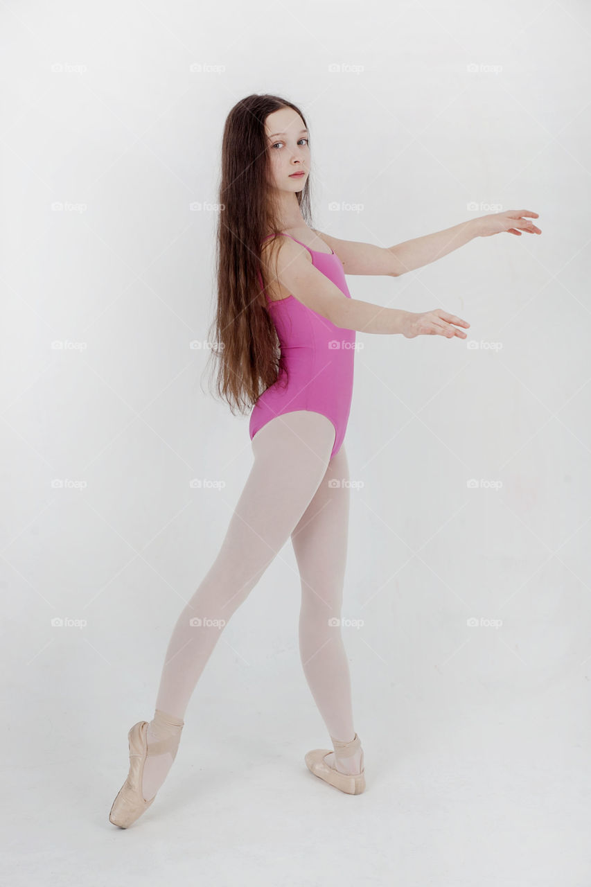 a girl in a pink in swimsuit and pointe shoes