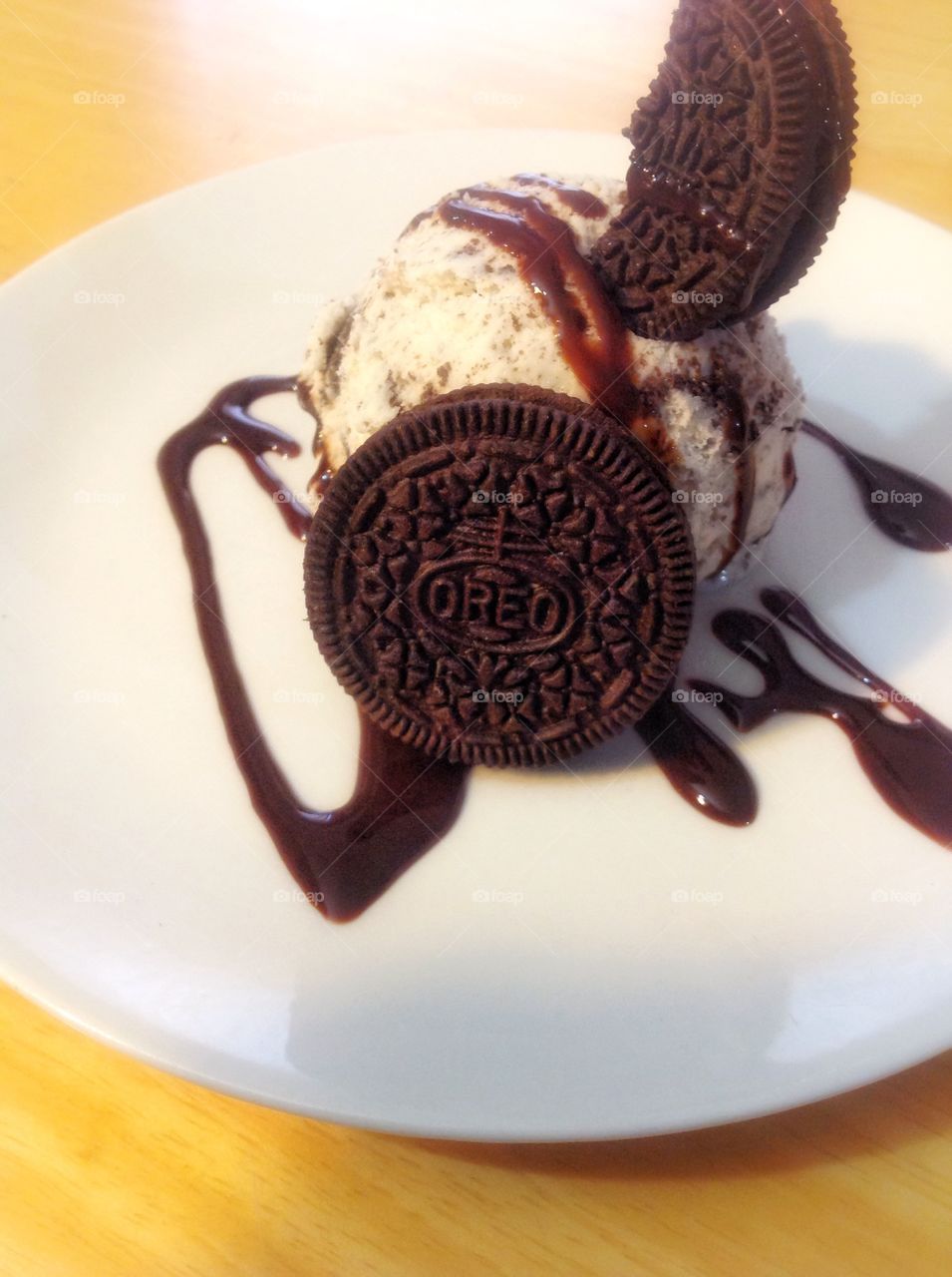 Oreo ice cream topped with chocolate syrup and Oreos 