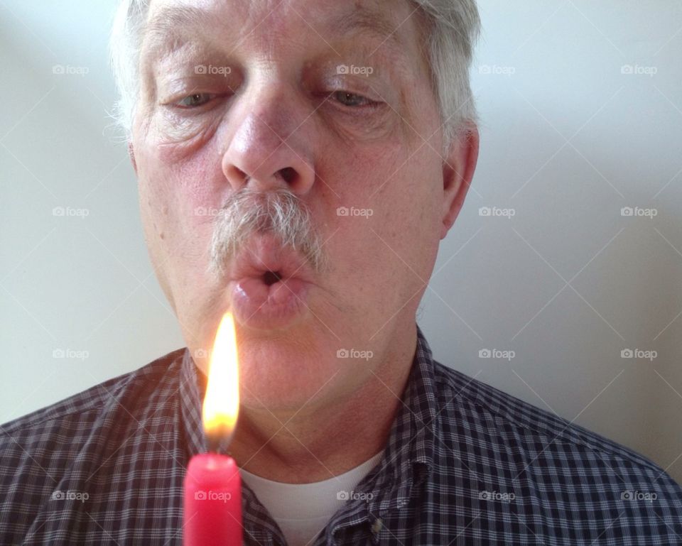 Man blowing out candle