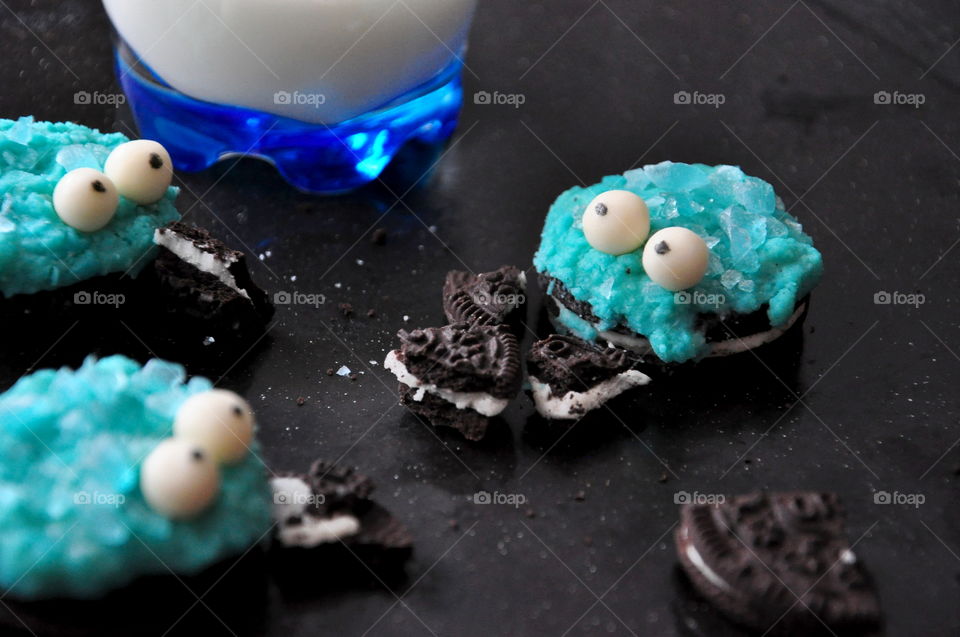 dessert oreo cookie monster blue with glass of milk on black surface