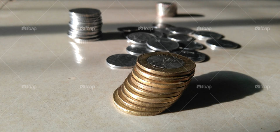 Indian currency coins in the shaped pattern in the marble background