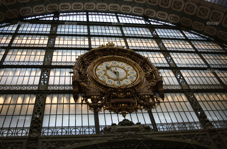 Large gilded clock in a former railroad station from Paris