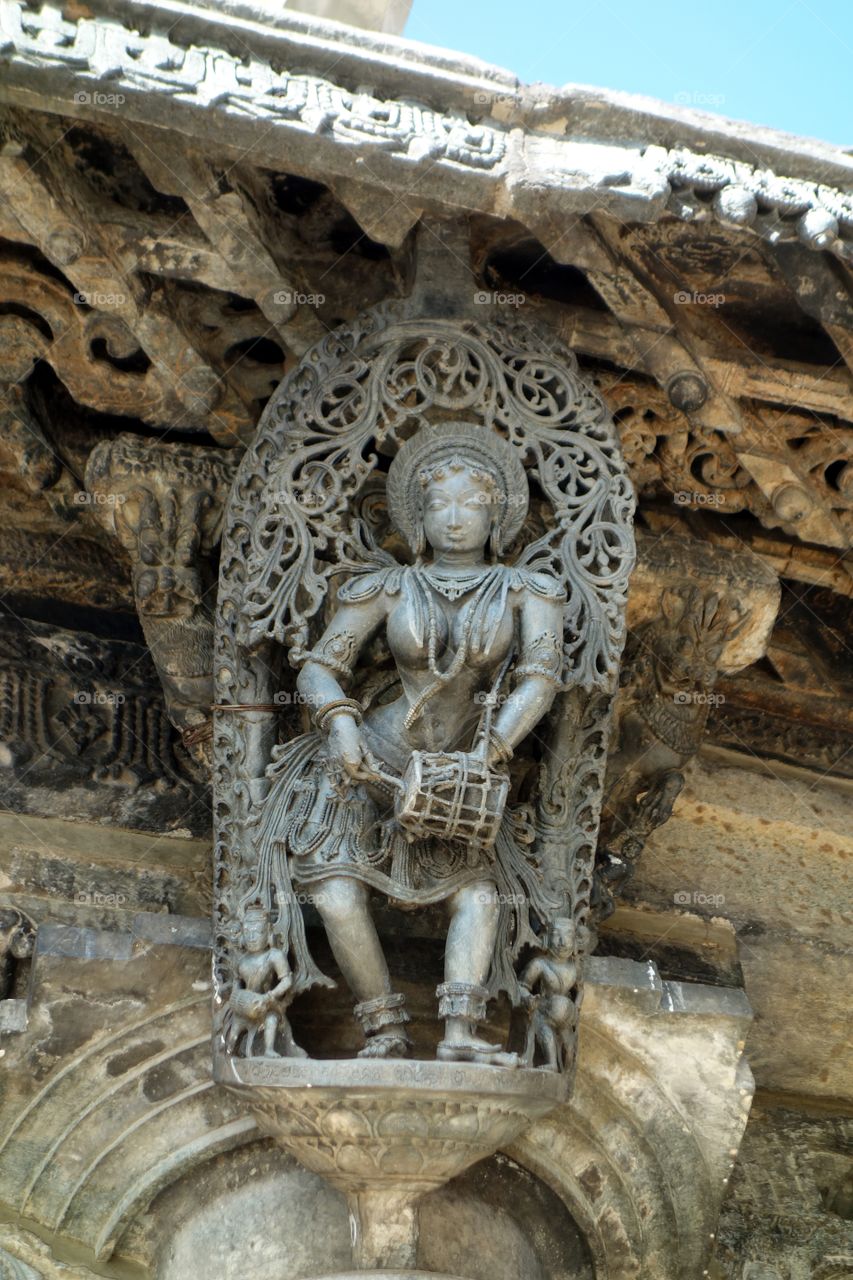 Belur Chennakeshava temple Apsara - playing drums - her left hand firmly grasp the drum