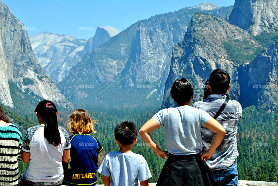 People looking at the beautiful view of Yosemite mountain, national park, taken behind their back, tourists taking a travel photo
