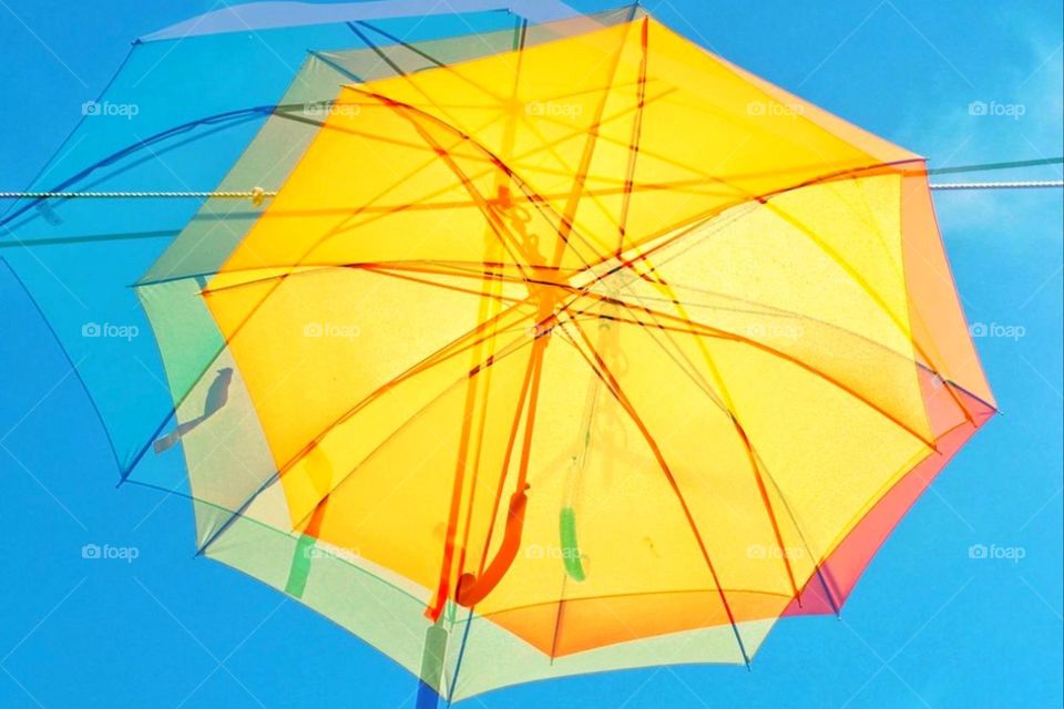 Multiple exposure of a parasol or umbrella against blue background