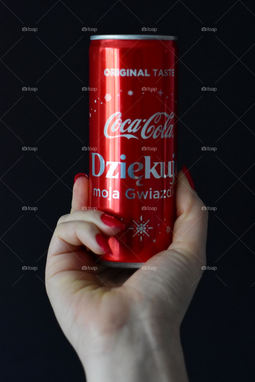 holding cola on black background