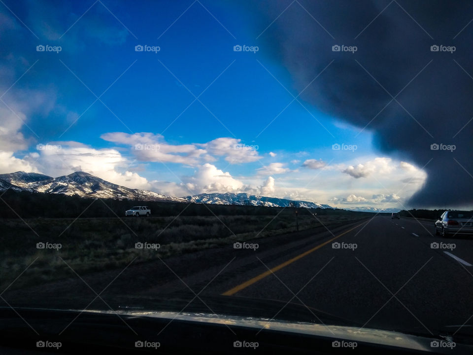 a storm takes over the highway and blue skies