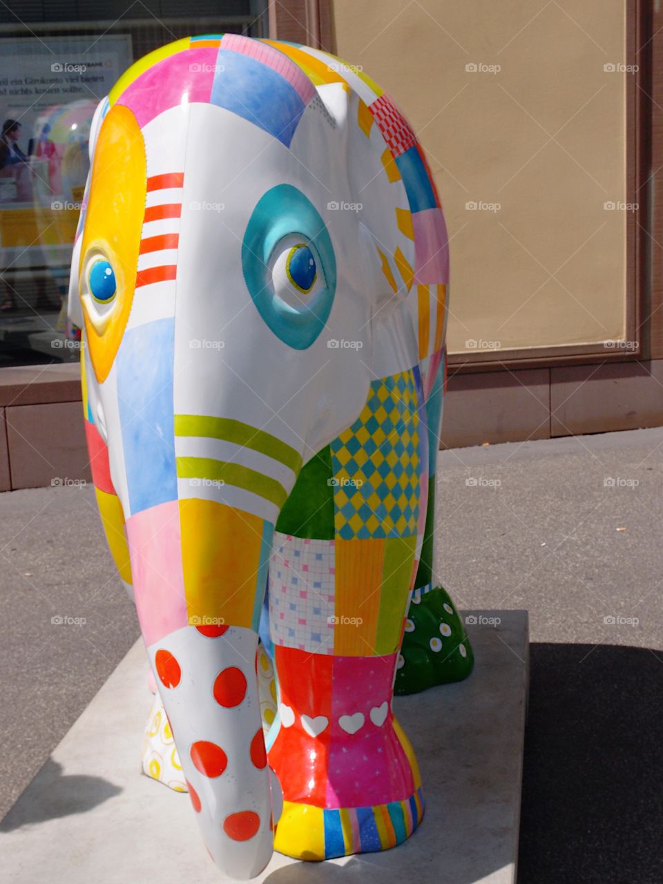 A large elephant statue with multiple colors and design patterns on it show the talent of an artist in a public square in Northwestern Germany on a sunny summer day. 