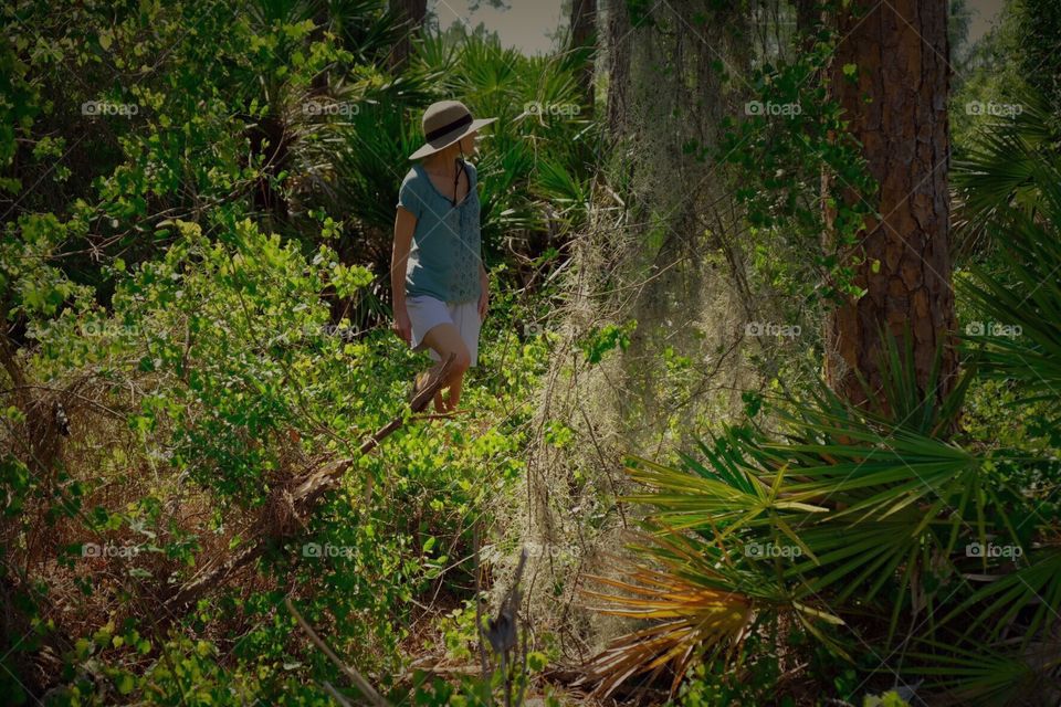 Woman hiking through a tropical Florida forest on a late summer day.