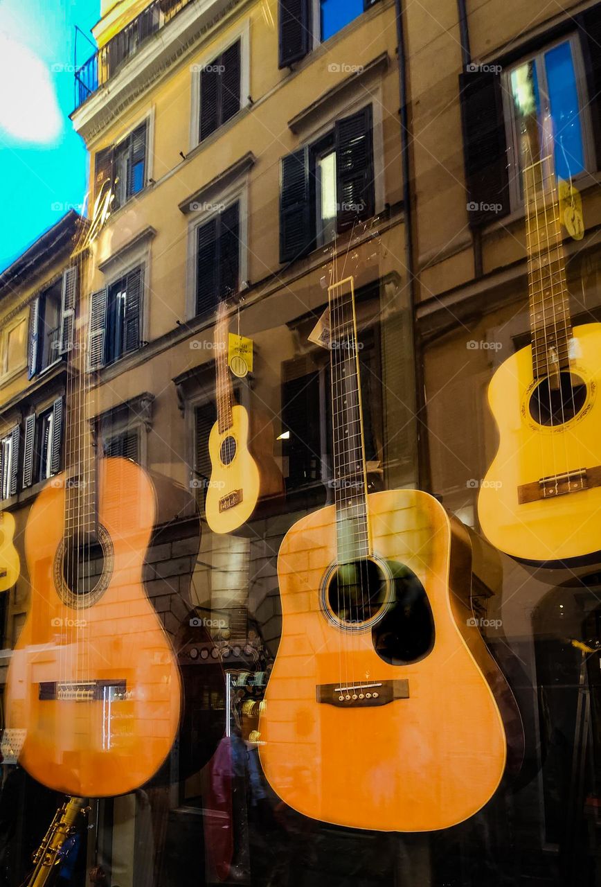House of Guitars - building reflected in the window of a guitar shop