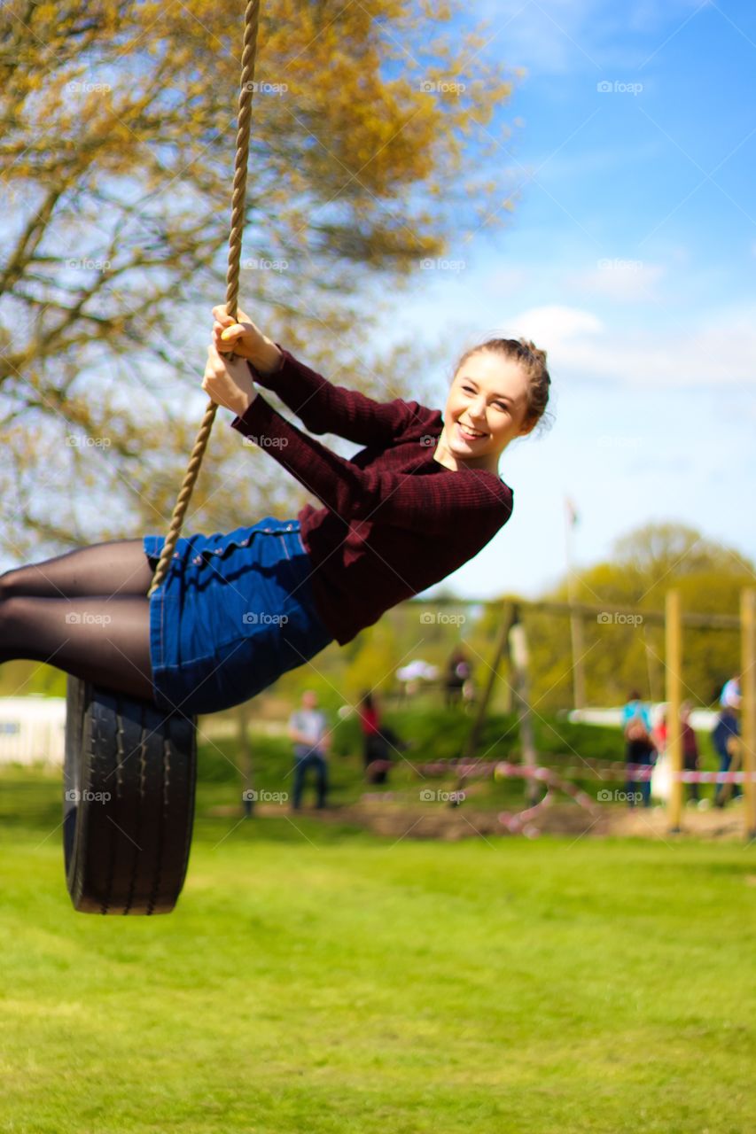Young woman enjoying on rope swing