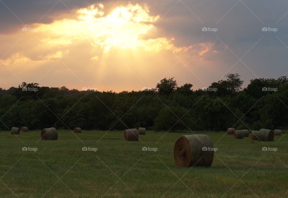 Sunlight streams thru clouds. Photo taken in OK after storm.  Setting sun streams thru break in clouds.