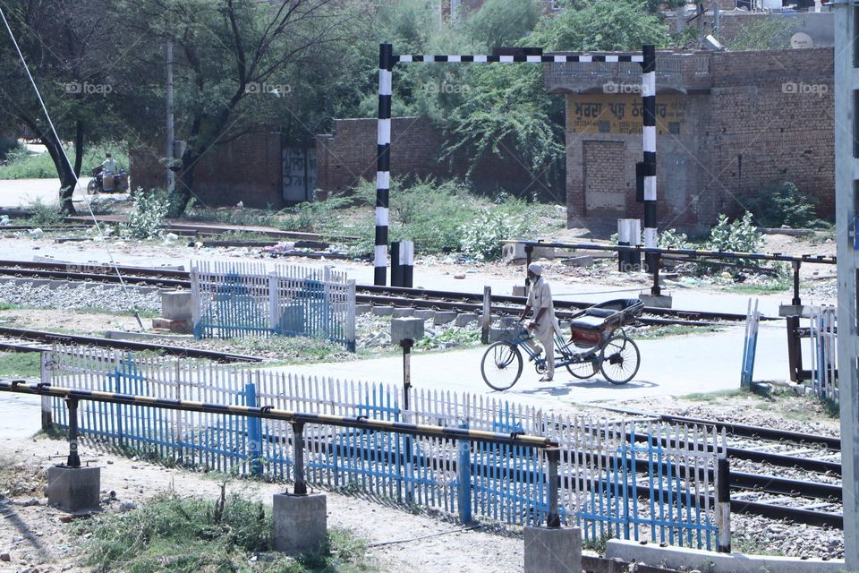 Hardworking riksha driver crosses railway track