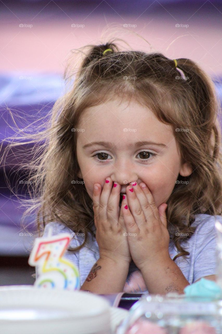 Young child excited to blow out her birthday candles on her special day 
