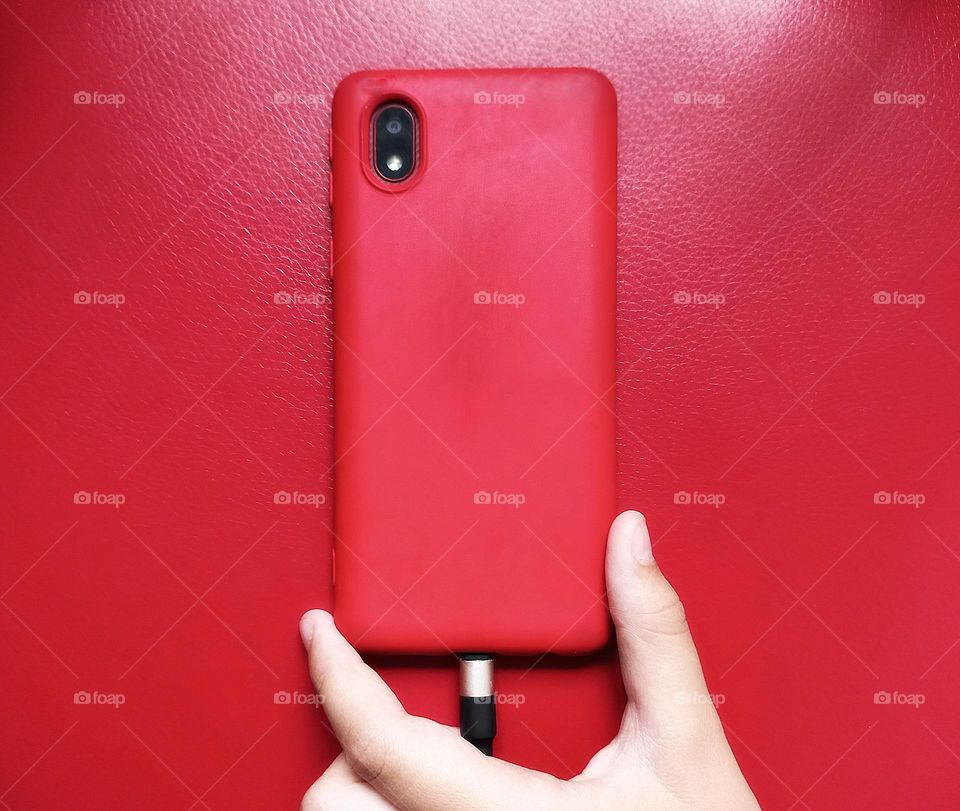 smartphone with a red case on a red background.
