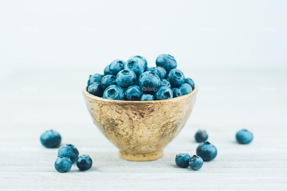 Fresh Blueberries in a Gold Bowl on a White Table