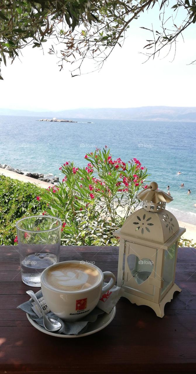 Drinking hot coffee at the seaside, admiring the view of a little islet. A lovely day in the middle of the spring...