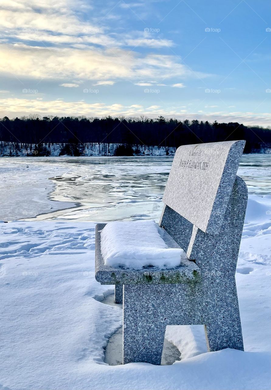 “In Memoriam.” A stone bench sits at the icy edge of high tide.