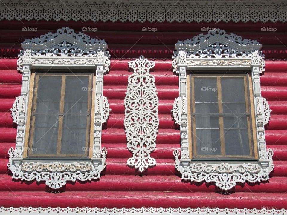 window with carved wooden architraves on houses in Russia
