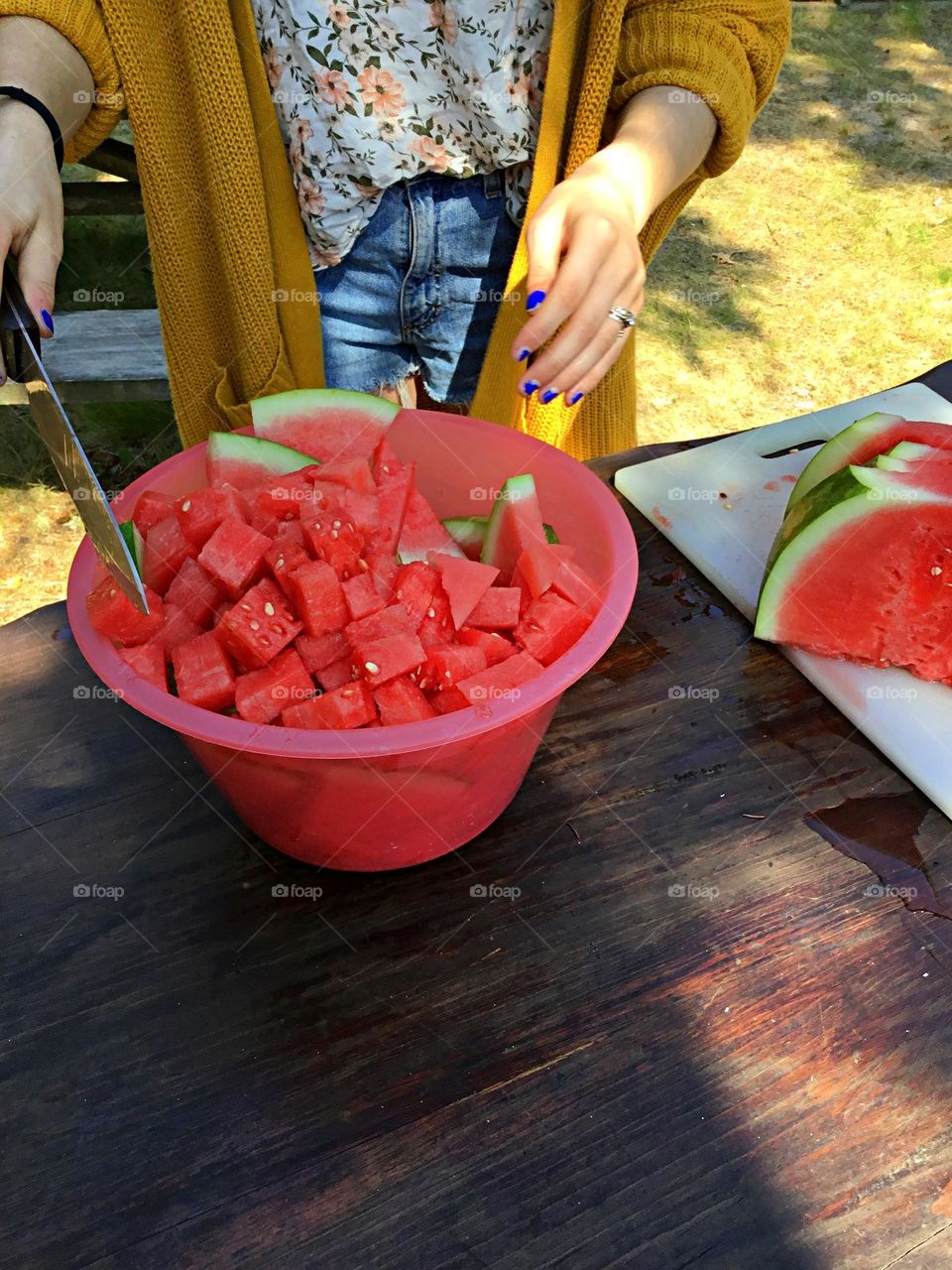 Urban Nature: Picnic in the Park - A woman in a state park cubes a ripe watermelon for a sweet, refreshing and traditional treat