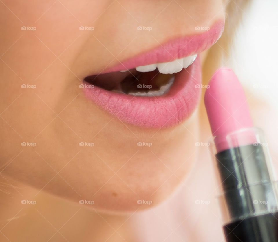 Close up cropped half face portrait, woman holding pink lipstick open mouth