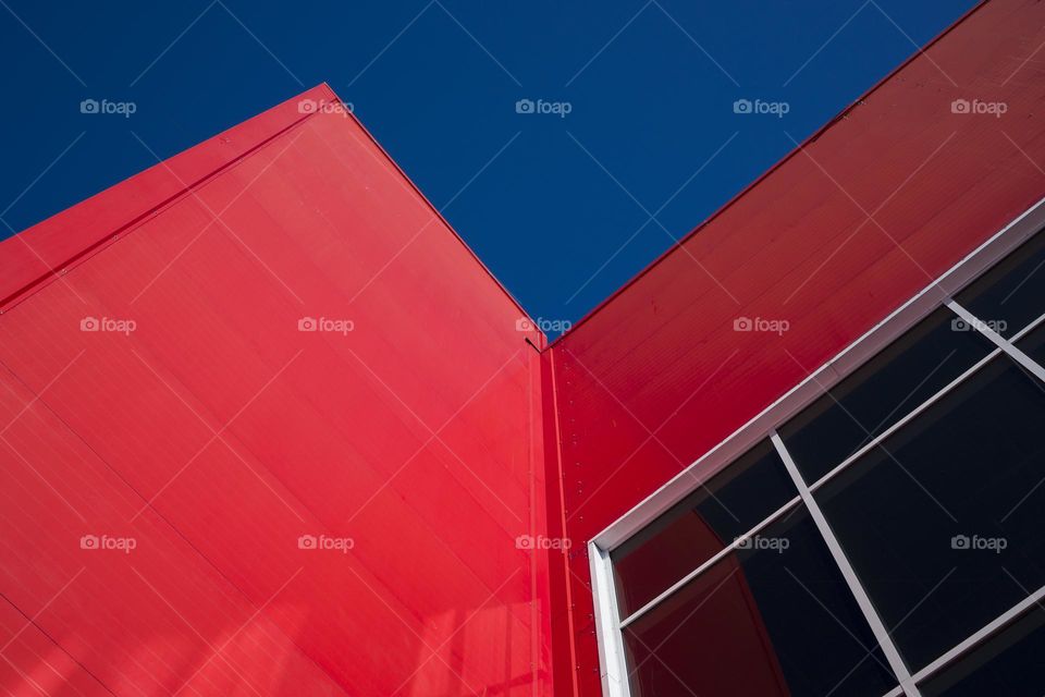 Low angle view of modern office building against blue sky