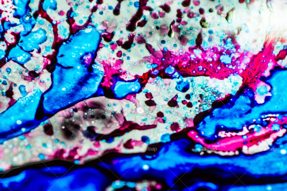 The ink to refill the printer cartridge was spilled onto the white washbasin and the paints blended into abstract drips and patterns.