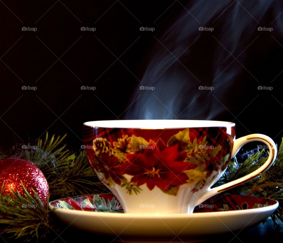 Still life in a Christmas setting with a steaming cup of hot tea