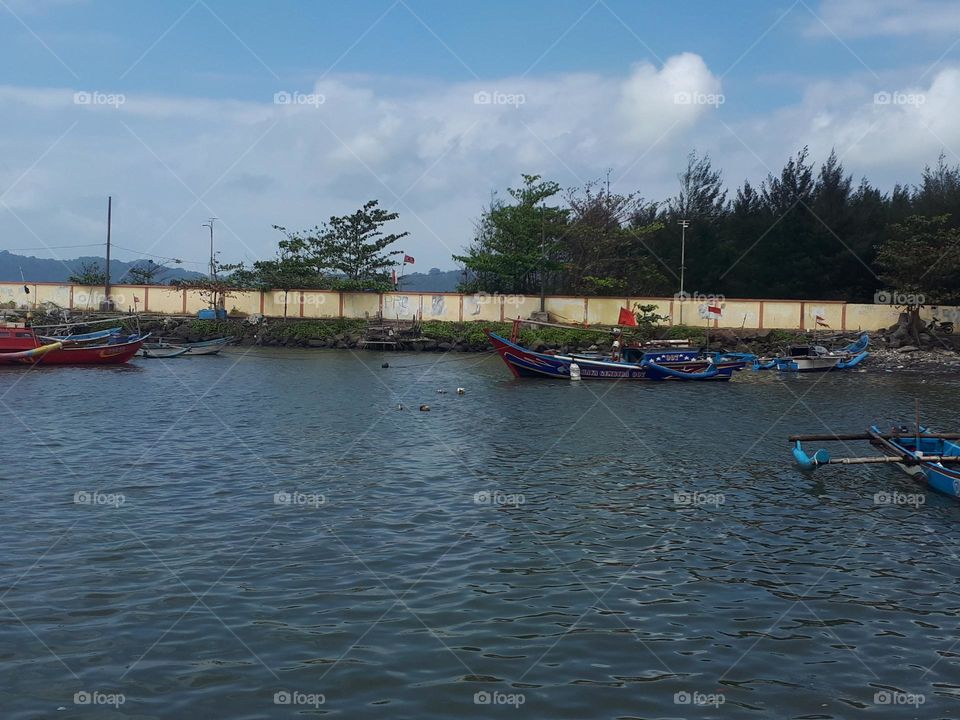 Cilacap, 2023, Indonesia : the fishing port is busy with people in the morning in sunny day