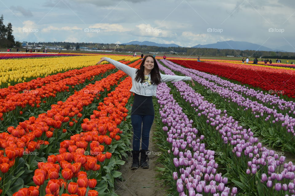 Happy young woman standing in flower field