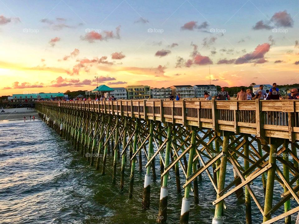 Looking back from the end of the fishing pier to the beach at the sunset