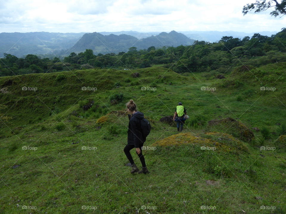 Girl and a guide hiking down the green hills in front of Penas Blancas, Nicaragua. Beautiful nature, amazingly green and vertile ground.