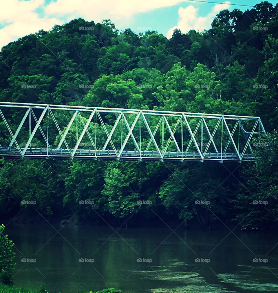 A one lane bridge over a beautiful river