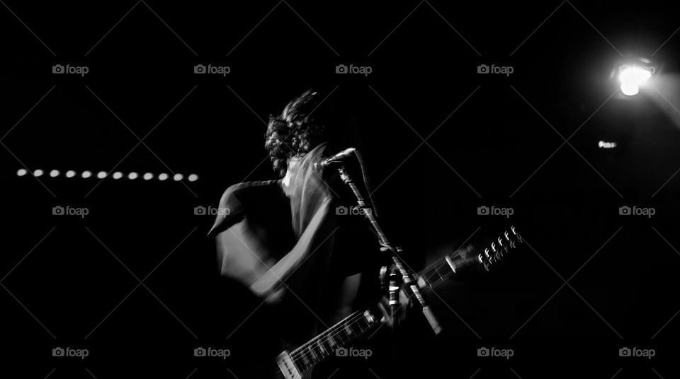 Lead singer in rock and roll band performing at a live concert