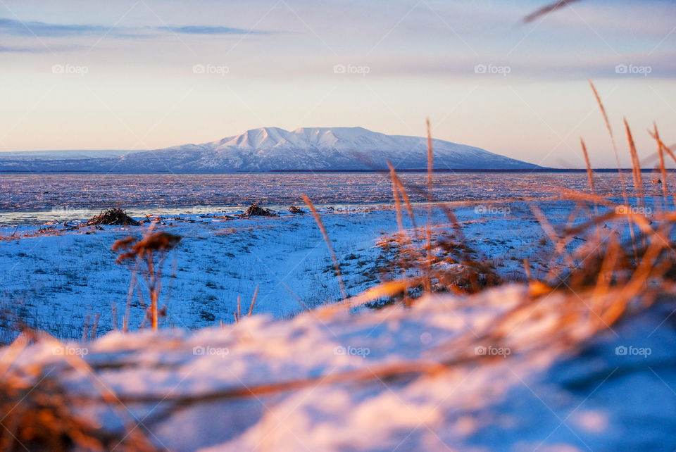 Warm light at sunset cast over a mountain in Alaska in winter 