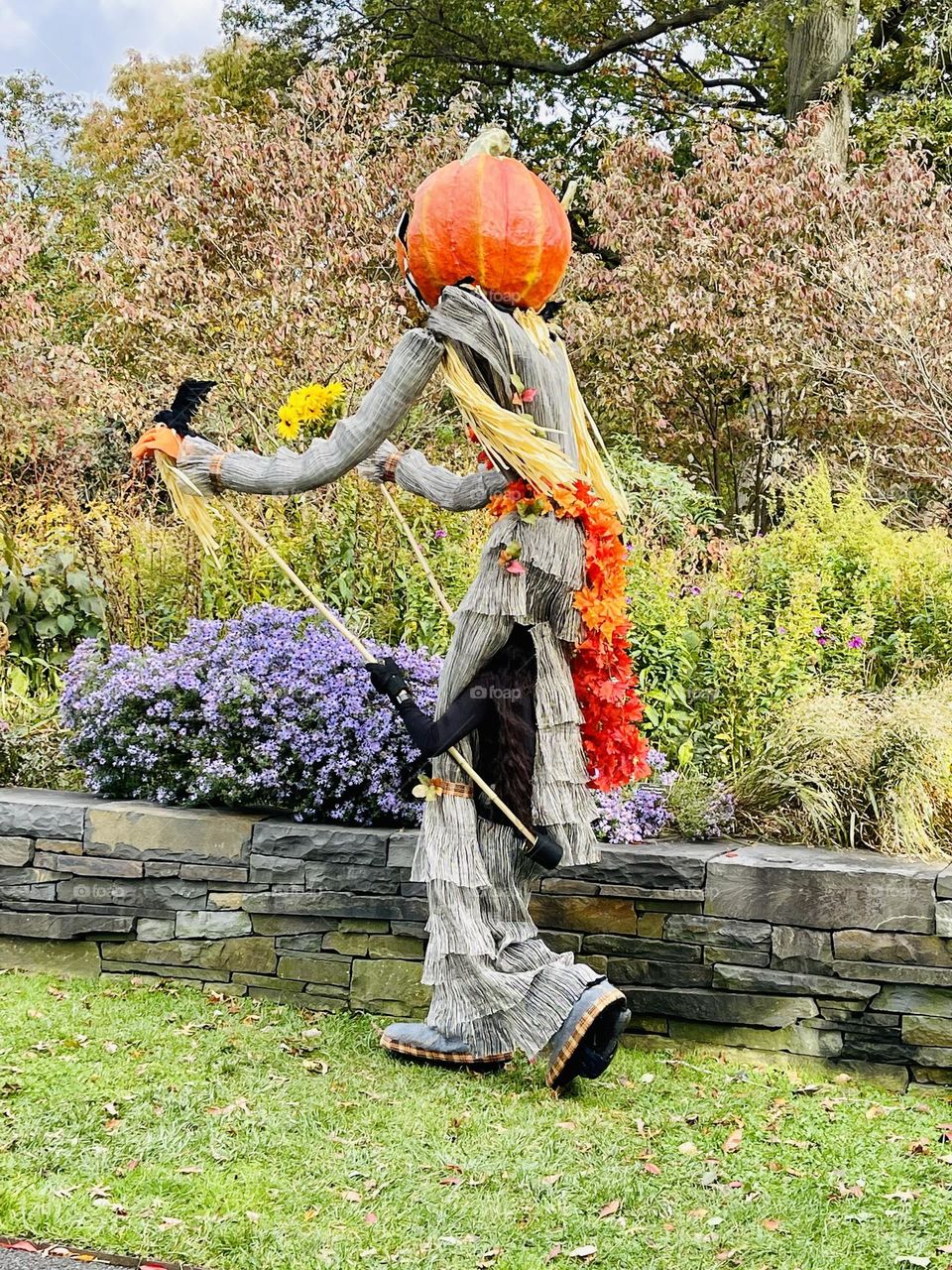 Pumpkin head figure taking a stroll through the park. 