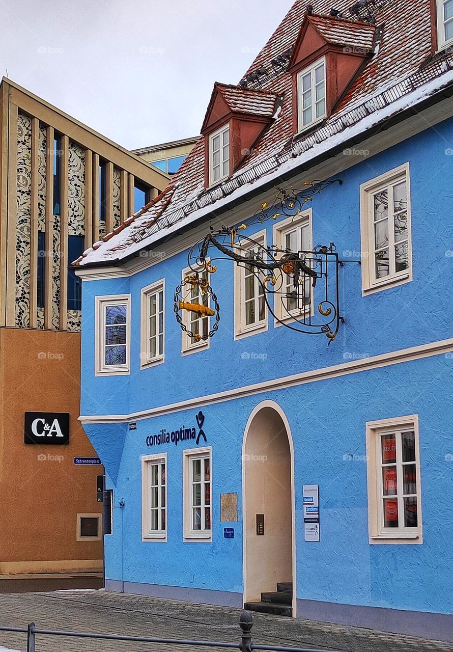 A beautiful photo of a bright blue building with nice windows and sign, a lovely building in blue