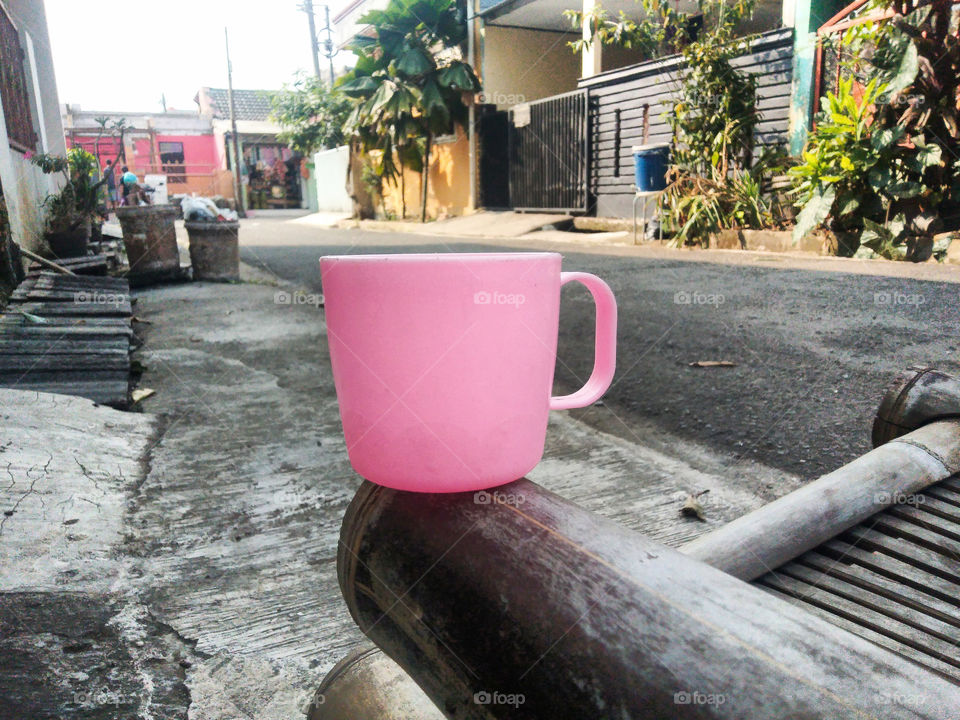 pink cup put on bamboo